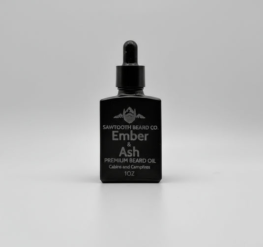 Black bottle of Sawtooth Beard Co Ember & Ash premium beard oil on a gray background